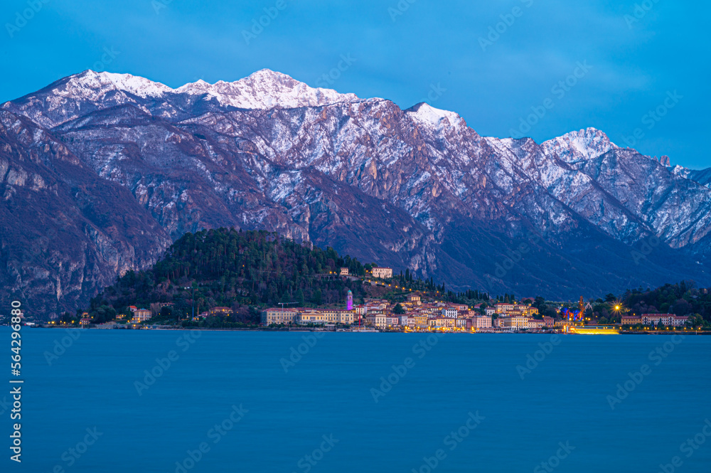 The town of Bellagio, photographed in winter, at dusk, from Tremezzina, with the snow-capped mountains. 
