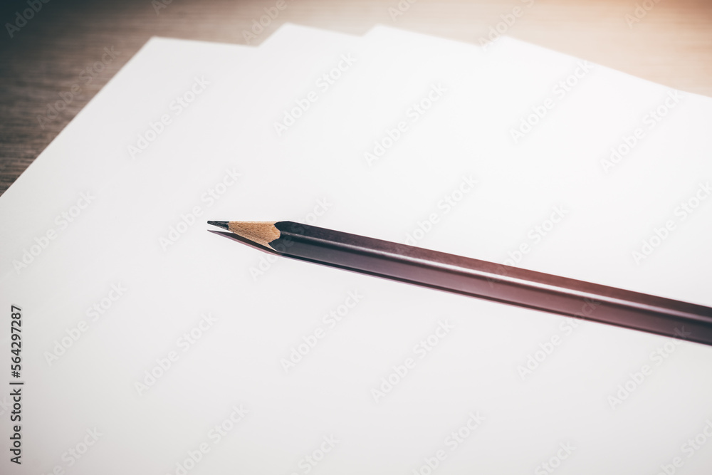 A black pen on the white plain paper for note, lecture and memo,on the wooden table, education concept A black pen on the white plain paper for note, lecture and memo,on the wooden table, education concept