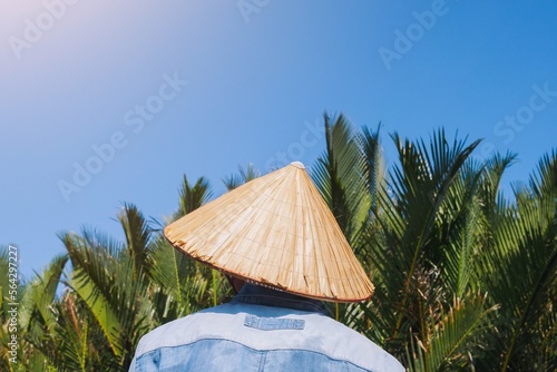 Wallpaper Mural A fisherman wears vietnamese hot (Asian conical hat) with coconut palm tree and blue bright sky background, Hoi an bamboo basket boat local tour Torontodigital.ca