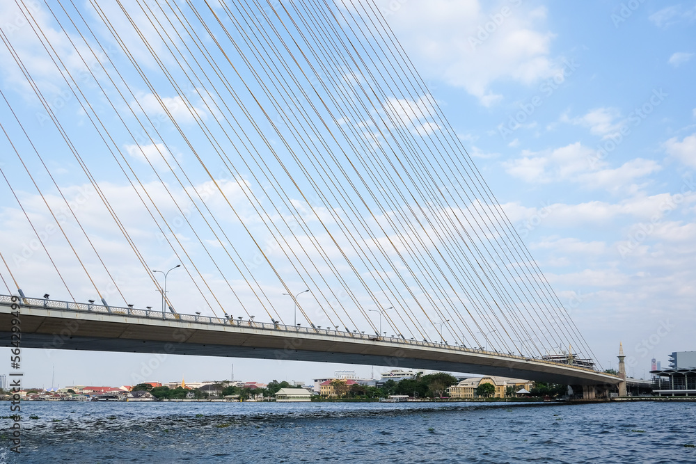 Obraz premium Thailand, Bangkok, view of the Rama VIII Bridge and the Chao Praya river under blue sky.