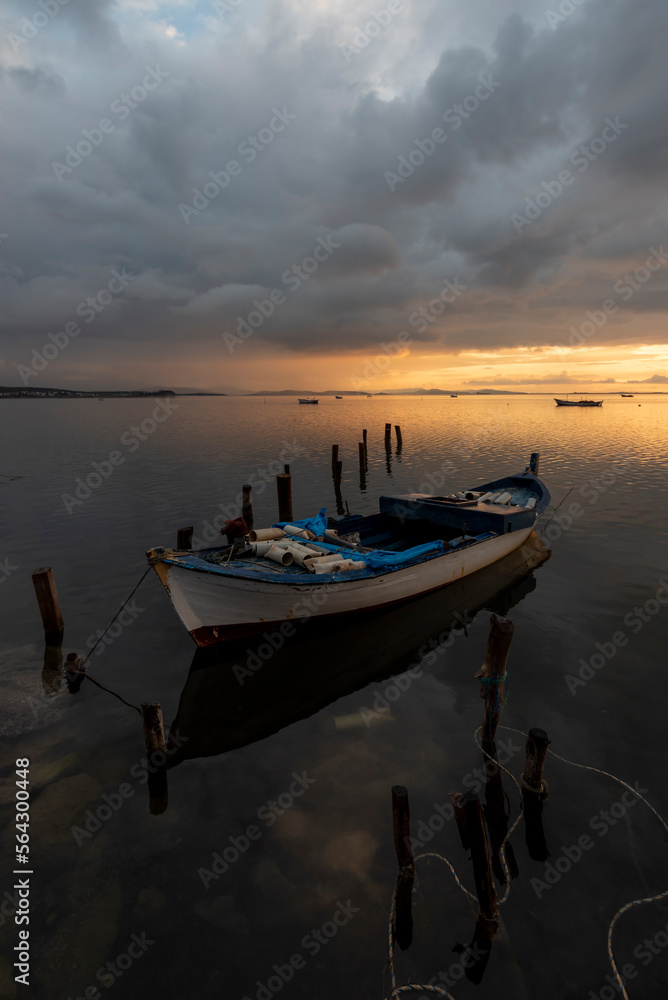 View of boats on sunset with reflection on the sea, colorful sky and clouds on sunset time with silhoutte of vehicles