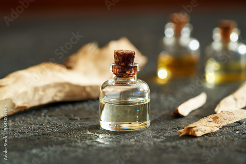 Essential oil bottle with pieces of white sandalwood on a table