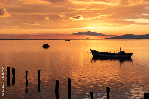 View of boats on sunset with reflection on the sea, colorful sky and clouds on sunset time with silhoutte of vehicles