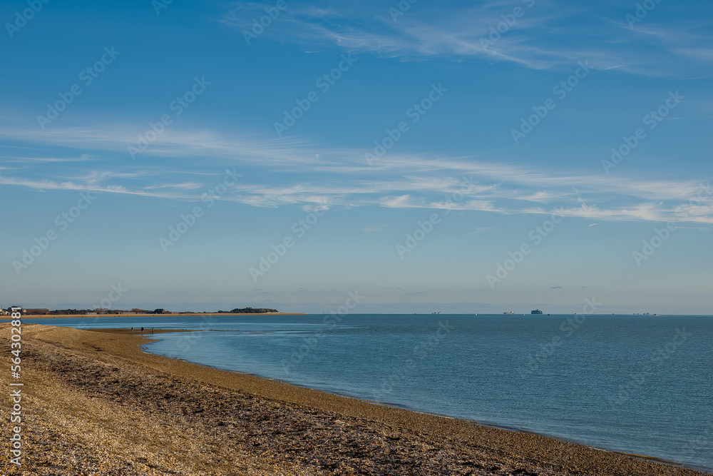 beautiful beach on a bright winter day with blue sky and wispy cloud at Browndown Hampshire England