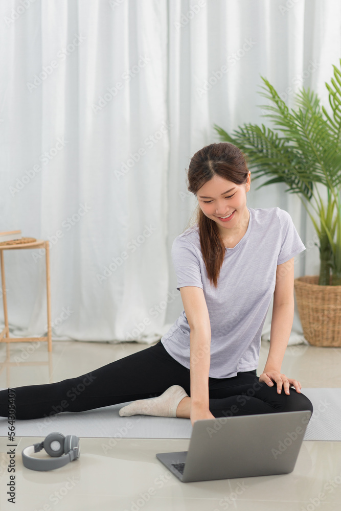 Yoga exercise concept, Young Asian woman doing yoga exercise with tutorial training online at home Yoga exercise concept, Young Asian woman doing yoga exercise with tutorial training online at home
