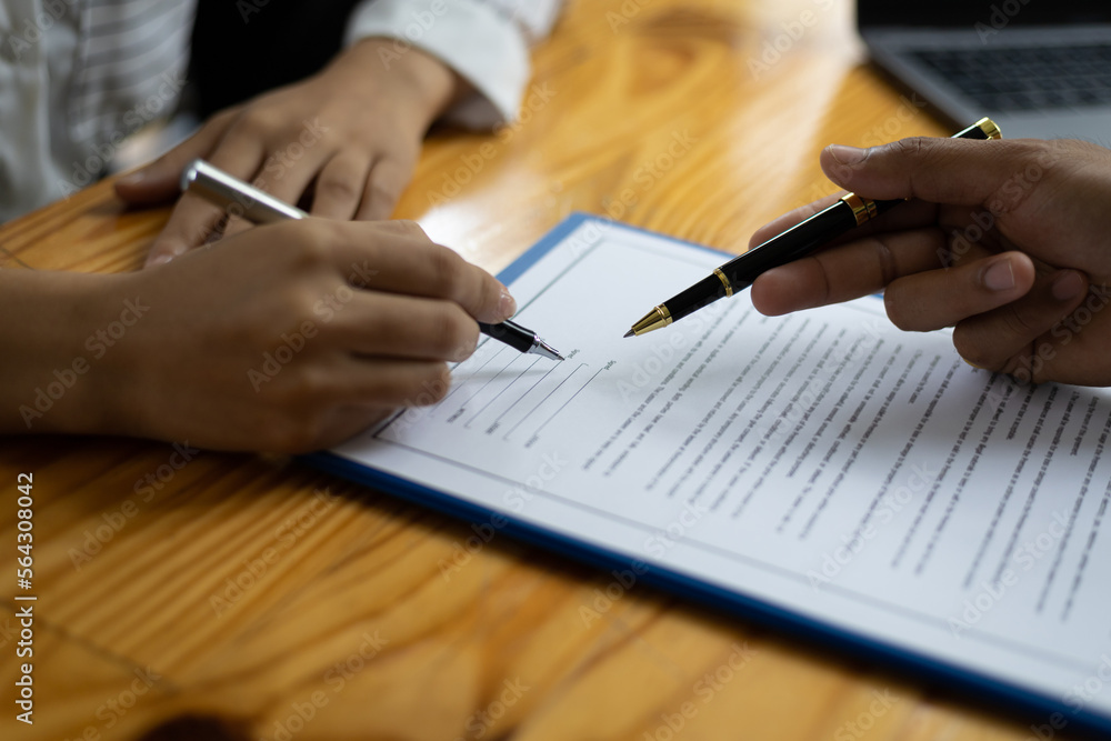 Signing a business contract agreement. Businessmen discuss and explain the details of the terms of the contract, a legal agreement. Signing a business contract agreement. Businessmen discuss and explain the details of the terms of the contract, a legal agreement.