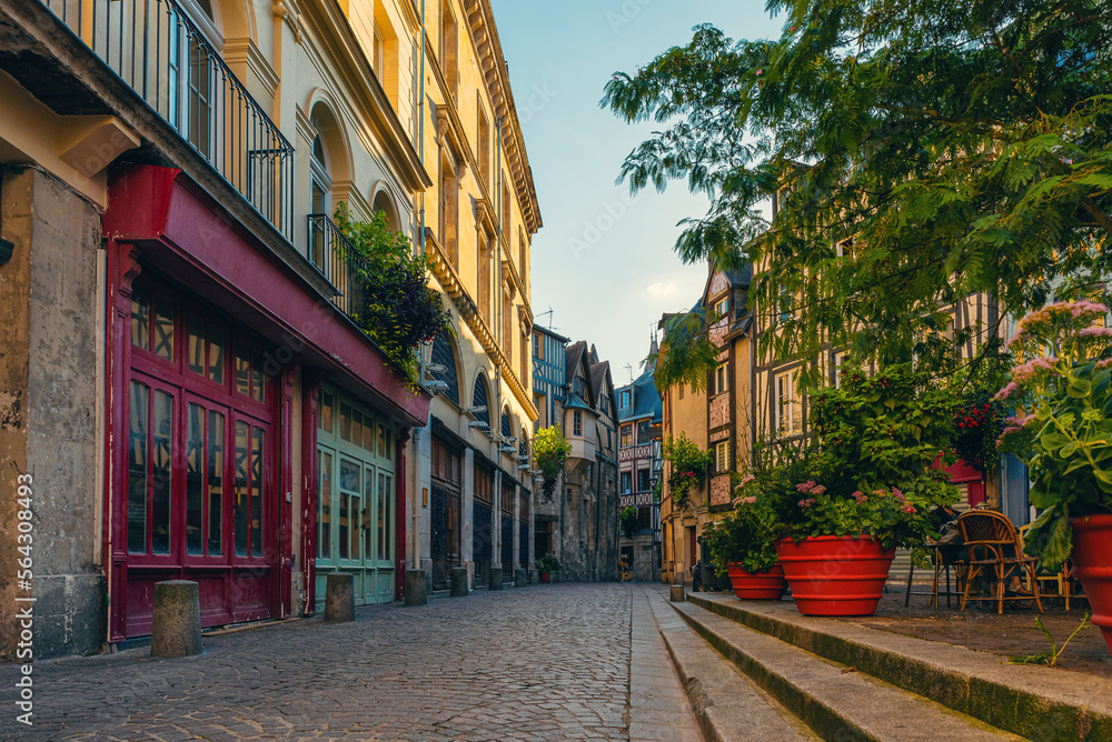 Old cozy empty street with timber framing houses, flower pots and cafe in Rouen, Normandy, France