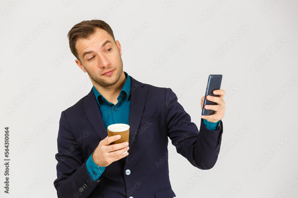 Confident young businessman using cell phone and drinking coffee Confident young businessman using cell phone and drinking coffee