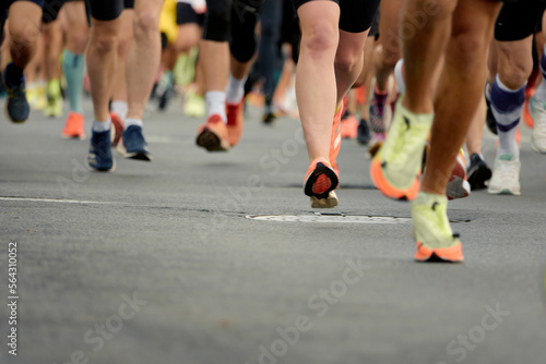 Marathon running race, people feet on city road. © Anna