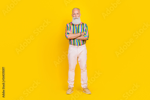 Full size portrait of concentrated cool granddad folded hands posing isolated on yellow color background