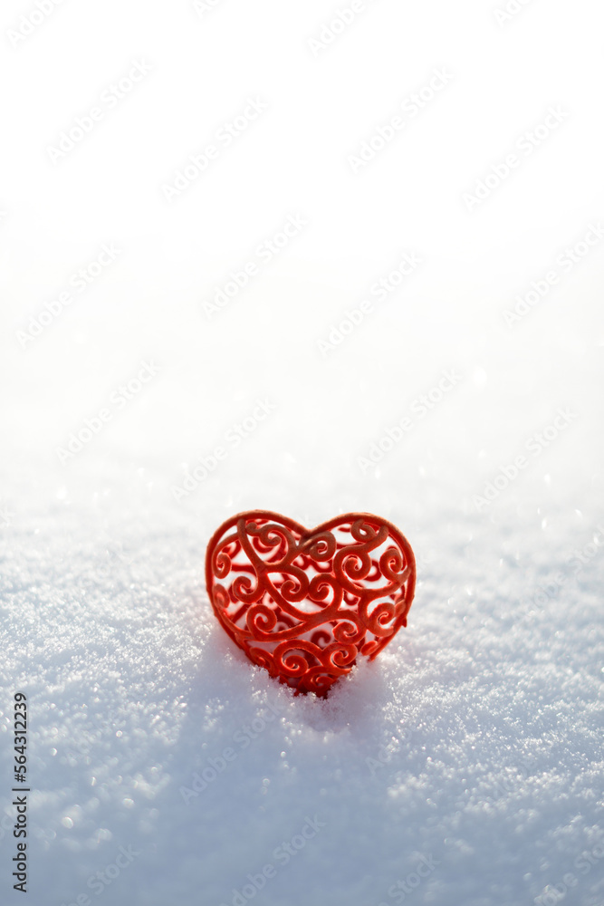 Fototapeta premium Red heart in white snow. Valentines day card, February 14 background. Red frozen heart on snowy background