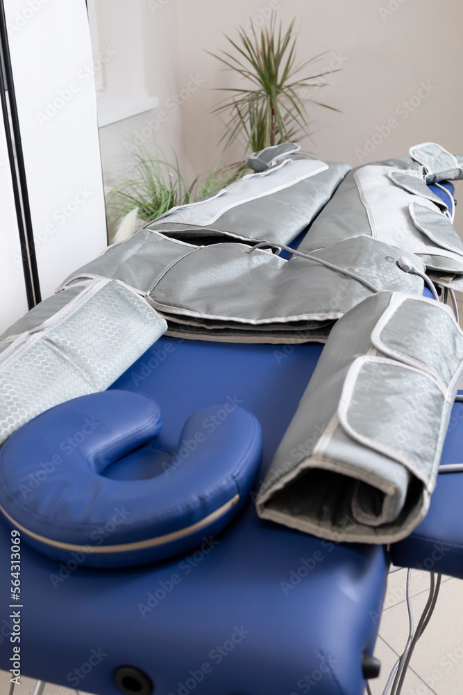 Pressure therapy gray massaging suit on blue couch in spa