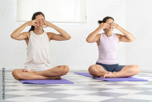 Bild auf Leinwand Two Latin American women doing Bhramari Pranayama, also known as Bee breathing technique