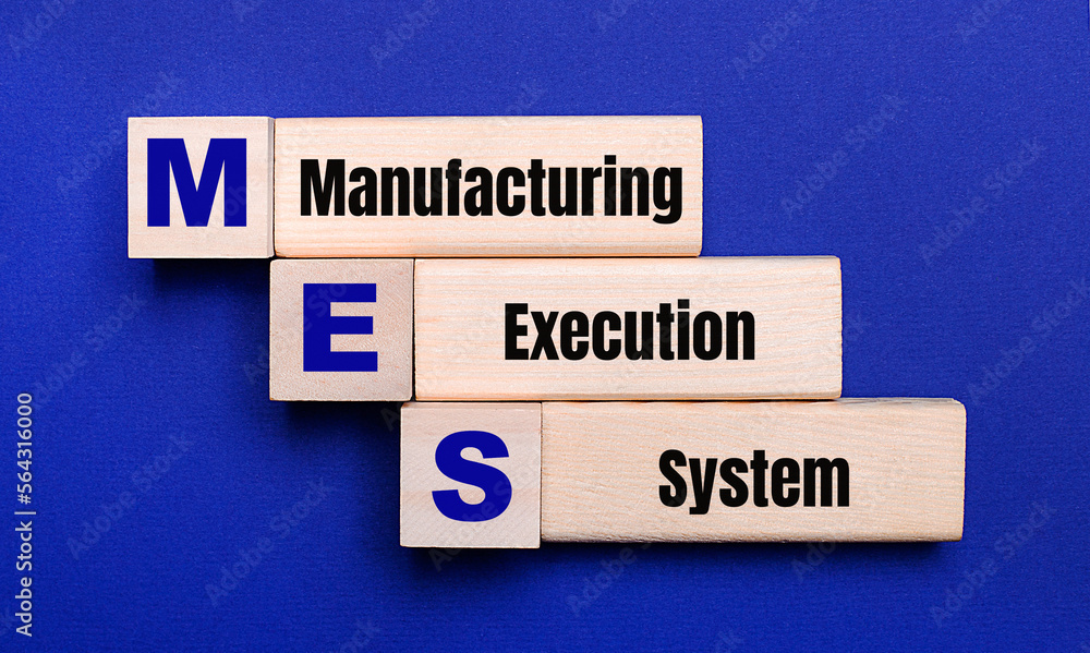 On a bright blue background, light wooden blocks and cubes with the text MES Manufacturing Execution System
