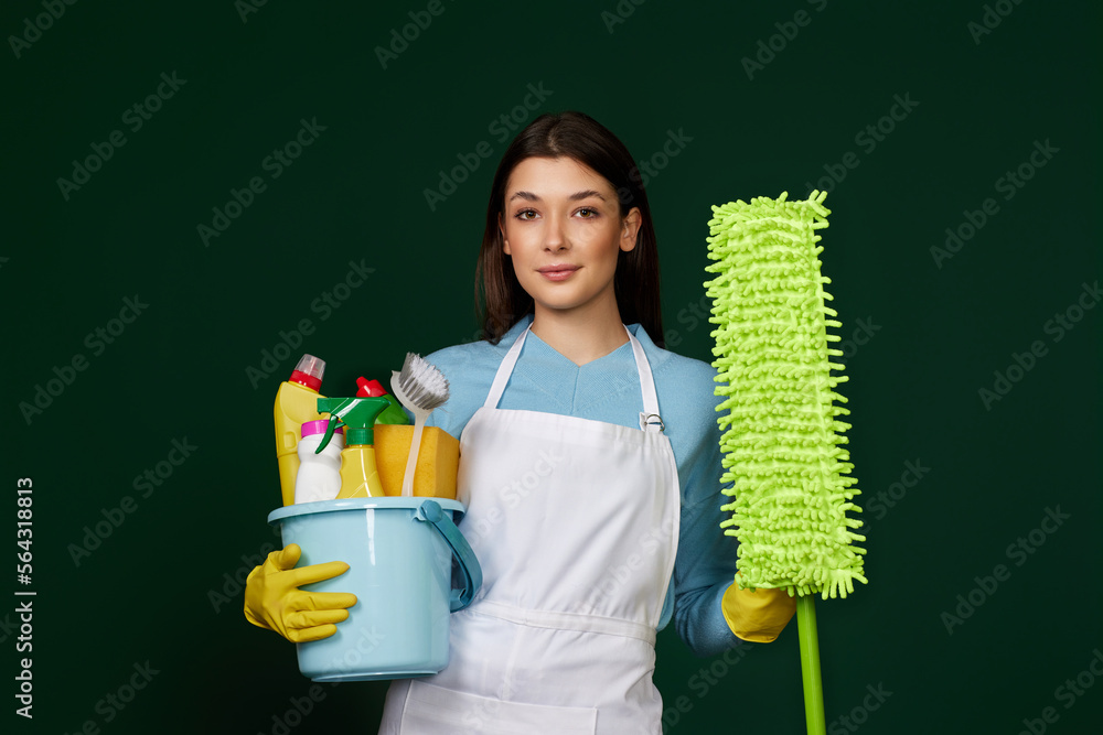 woman in cleaner apron holding bucket of detergents and mop