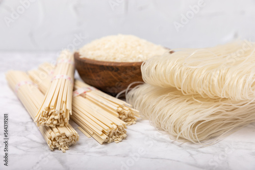 Rice noodles.Rice and noodles with rice flour in a wooden plate on a white marble background.Close-up.Useful and healthy food. Place for text. Copy space.
