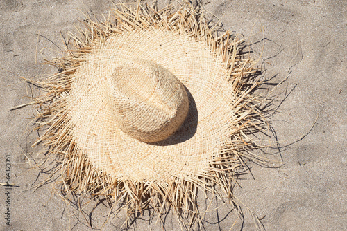 Straw hat on the sandy beach. View from above.