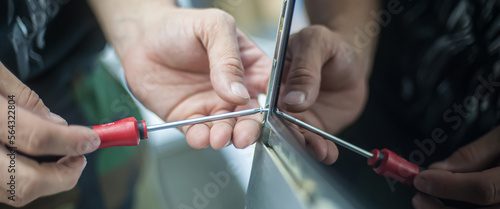 Maintenance, professional service cleaning. A repairman opens a computer monitor with a screwdriver. Close-up of specialized manual cleaning of laptop.