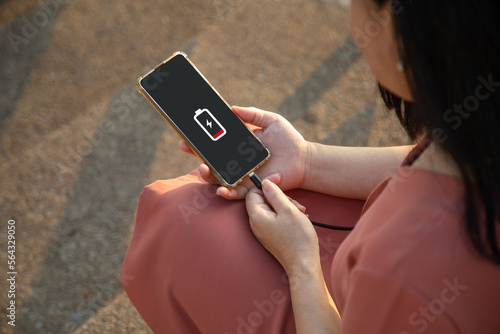 Close up a woman hands charging her smart phone with charging icon