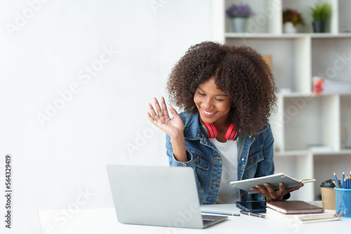 Beautiful Asian businesswoman is on video call with customer on laptop in office and has a negotiating gesture smiling and happy face.