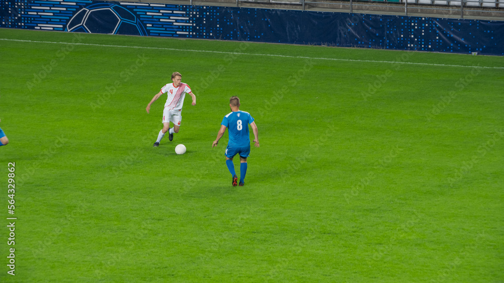 Fototapeta premium Stadium Soccer Football Match Championship: White Team Attacks and Plays in Pass. Action Game on a International Tournament. Live Sport Broadcast Channel Television Concept.