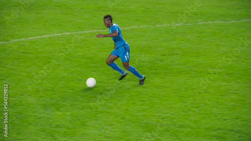 Professional Soccer Football Match Championship Event: Blue Team Attacks, Black Forward Masterfully Dribbles on an International Tournament. Television Channel Broadcast Concept.