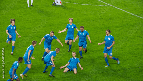 Championship Match: Blue Soccer Football Team Attack, Player Run Happy after Scoring Goal, Celebrate Victory, Doing Knee Slide. Sport Channel Broadcast Television Concept. © Gorodenkoff