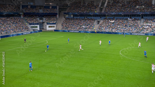 Soccer Football Championship Stadium with Crowd of Fans: Blue Team Forward Attacks, Dribbles, Players Defending The Goals, Ready To Counterattack. Sport Channel Broadcast Television. High Angle Wide. © Gorodenkoff