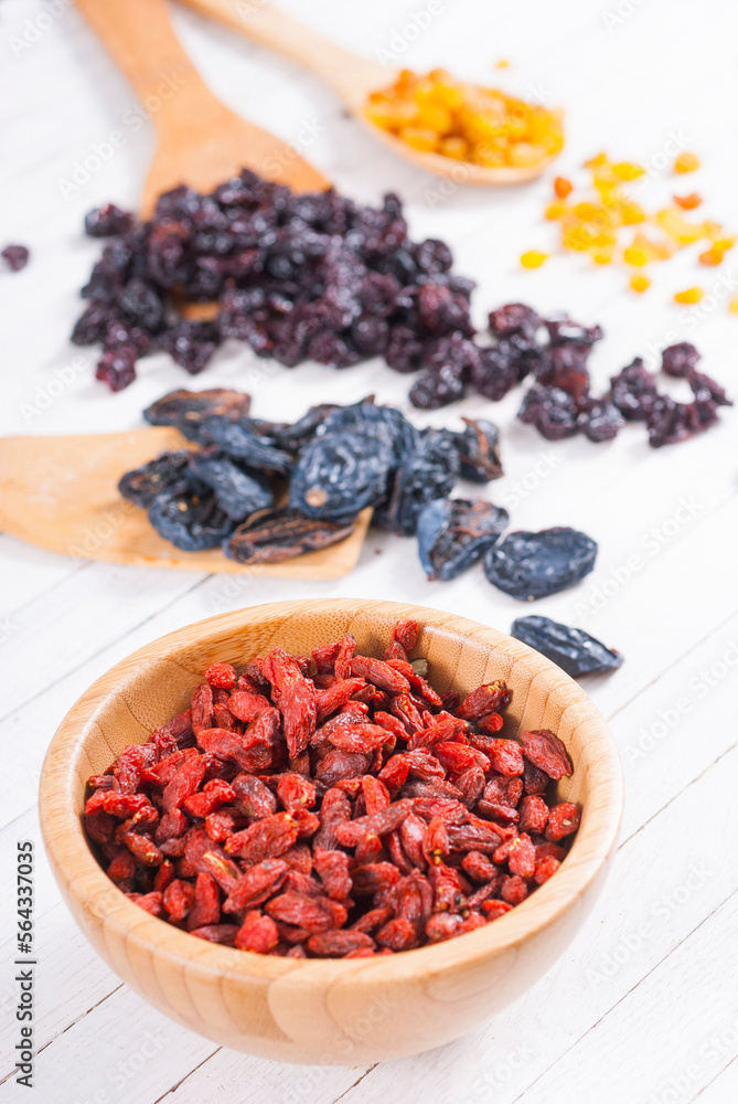 dried goji, cherry, raisin and plum fruits on white wood dried goji, cherry, raisin and plum fruits on white wood