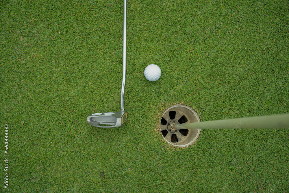 Obraz premium Golf ball and golf club on green in the evening golf course with sunshine in thailand.