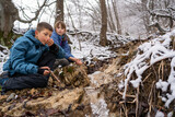 Children drinks mineral water from natural spring. The concept of travel to the wild in the winter