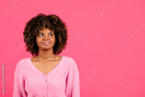 Cheerful confident millennial african american curly female in casual looking at copy space