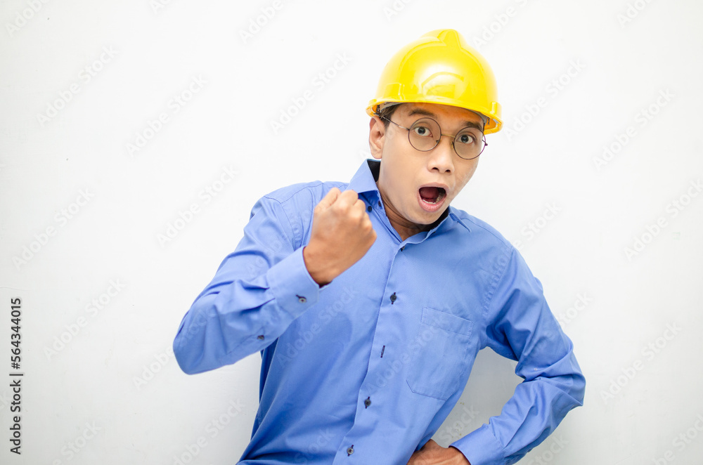 asian construction worker wearing yellow safety helmet shouting with shocked and surprised expression. asian construction worker wearing yellow safety helmet shouting with shocked and surprised expression.