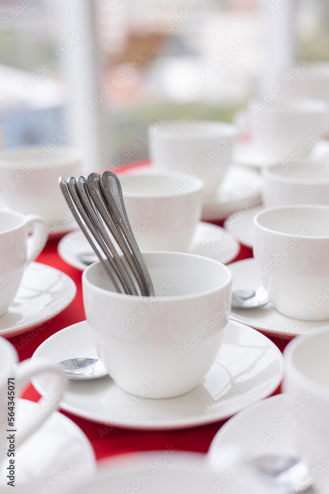 set of white tea cups on red tablecloth set of white tea cups on red tablecloth