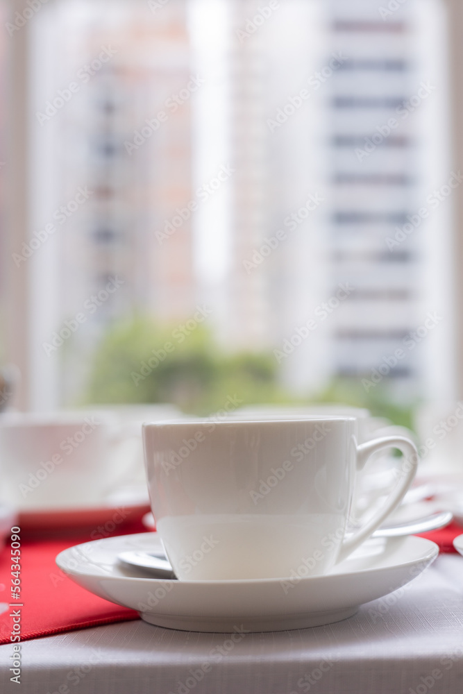 set of white tea cups on red tablecloth set of white tea cups on red tablecloth