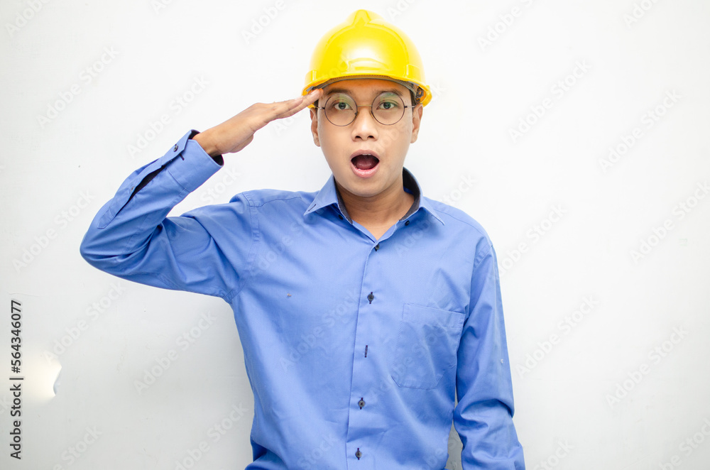 asian construction worker wearing yellow safety helmet shouting with shocked and surprised expression.