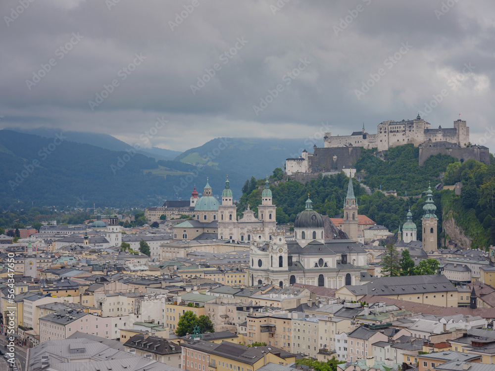 Fototapeta premium Salzburg Austria inner city with churches. Beautiful view of Salzburg skyline with Festung Hohensalzburg in cloudy summer, Salzburg, Salzburger Land, Austria. Hohensalzburg fortress and Salzburger Dom