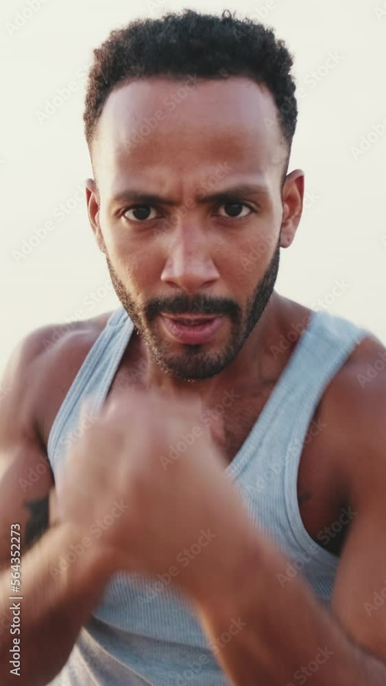VERTICAL VIDEO: Close up, young bearded male fit athlete boxer practicing punching technique while standing on the embankment VERTICAL VIDEO: Close up, young bearded male fit athlete boxer practicing punching technique while standing on the embankment