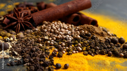 Oriental Indian spices on the table. Cumin, coriander, turmeric, allspice, black pepper, star anise, cinnamon close-up. Banner