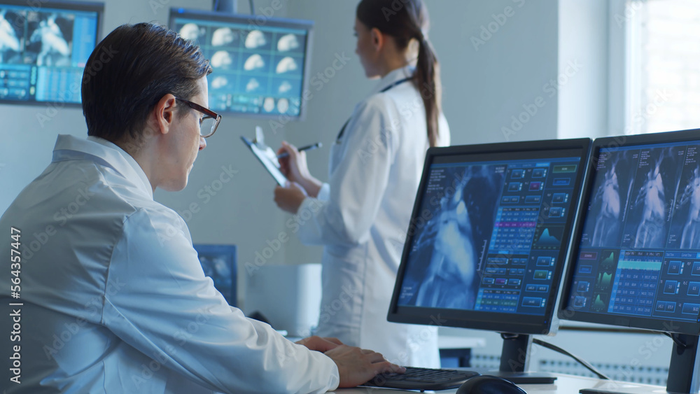 Professional medical doctors are maksing computer research in hospital office. Medicine, healthcare and cardiology concepts. Professional medical doctors are maksing computer research in hospital office. Medicine, healthcare and cardiology concepts.