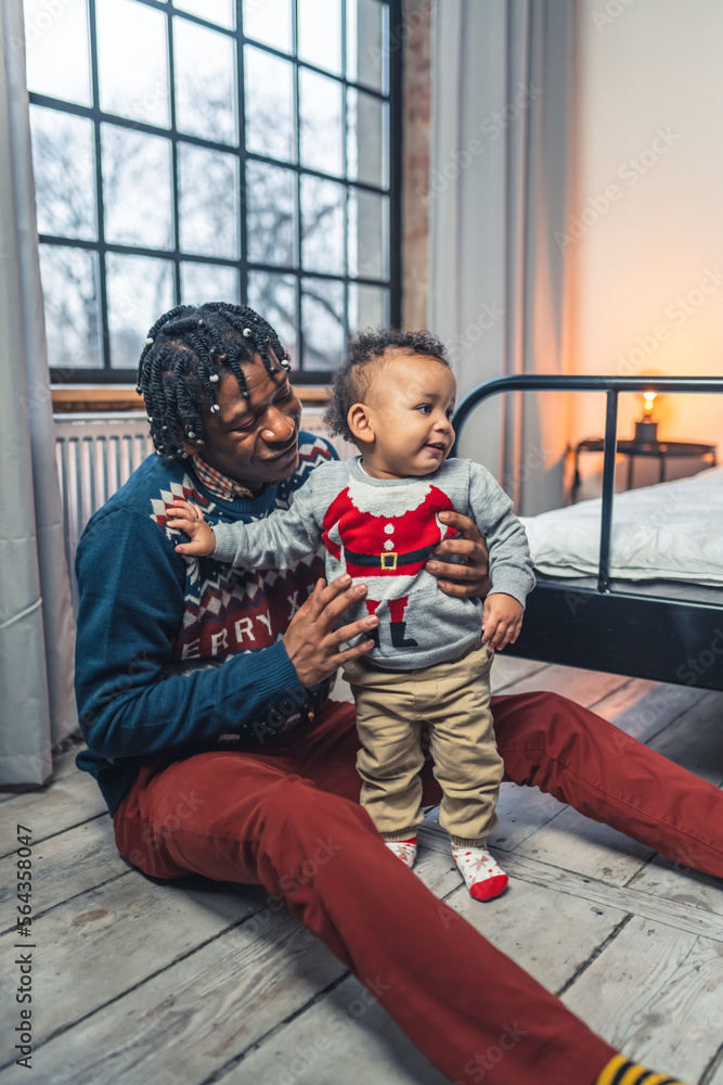 Father and his toddler son wearing Christmas clothes. High quality photo