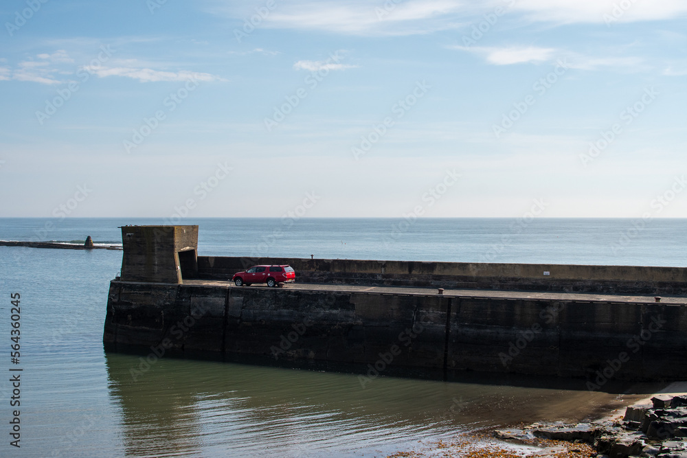 Port, harbour and sea defences at Craster; fishing village in Northumberland, UK
