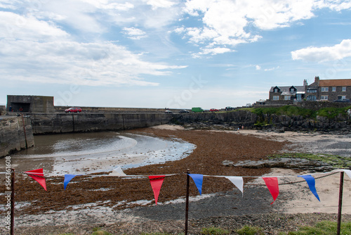 Views towards Craster harbour and beach in Northumberland, UK. With bunting during Queen Elizabeth II Platinum Jubilee celebrations photo
