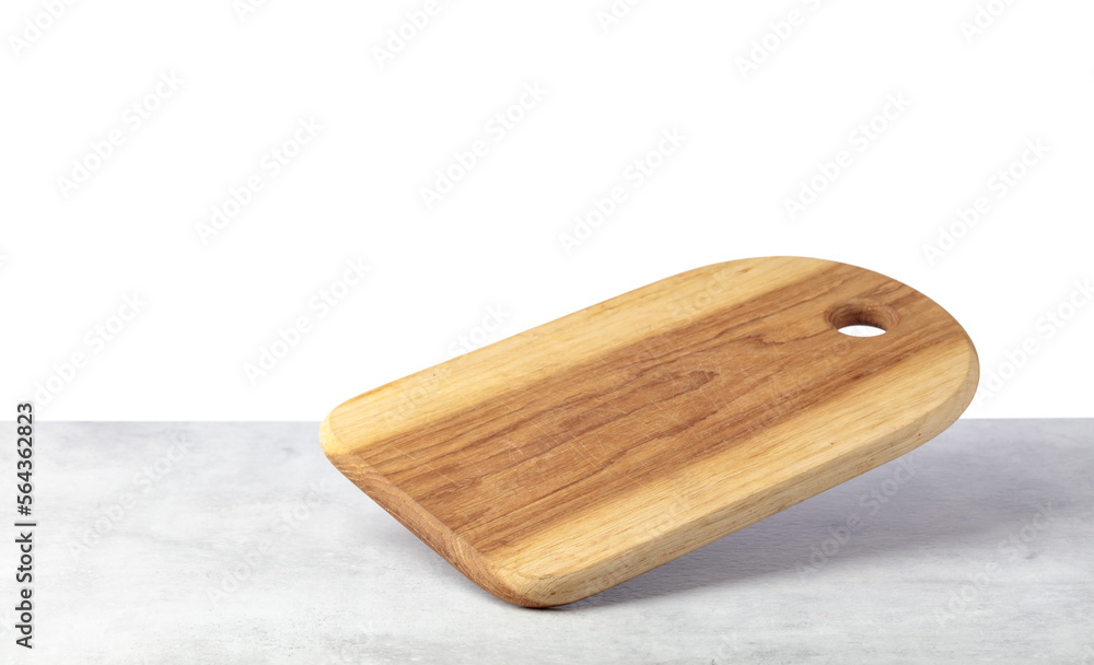 Cutting board falling on a grey stone table.