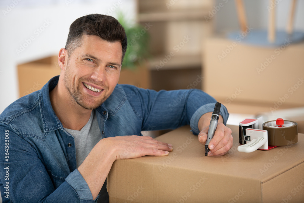 happy man is writing on a box happy man is writing on a box