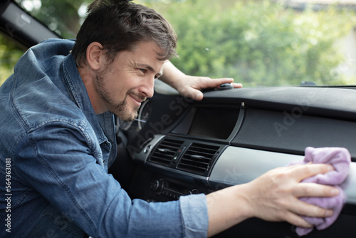 man cleaning the car dashboard