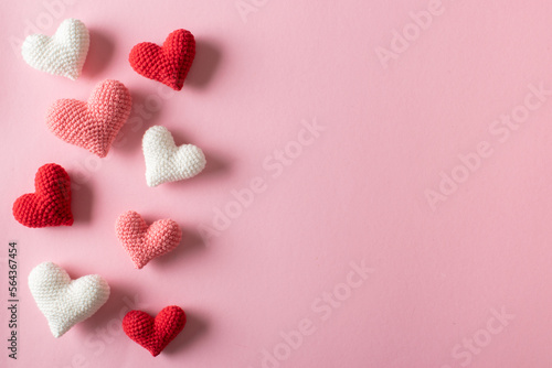 Background of knitted hearts on a light pink background for Valentine's Day.