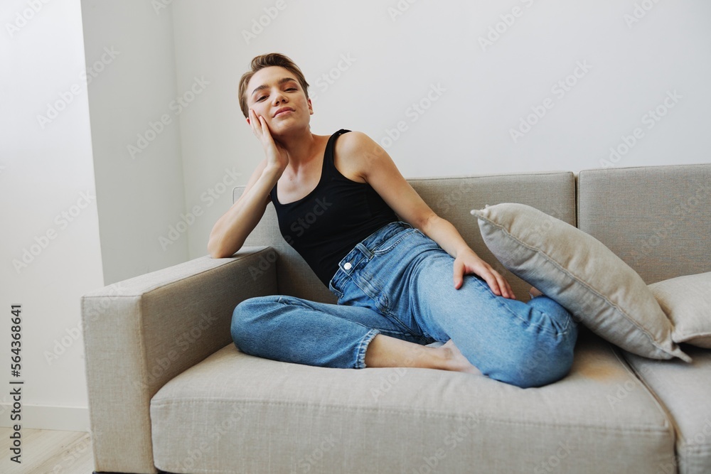 Young woman with short haircut hair having fun at home on the couch smile and happiness, vacation at home, natural posing without filters, free copy space Young woman with short haircut hair having fun at home on the couch smile and happiness, vacation at home, natural posing without filters, free copy space