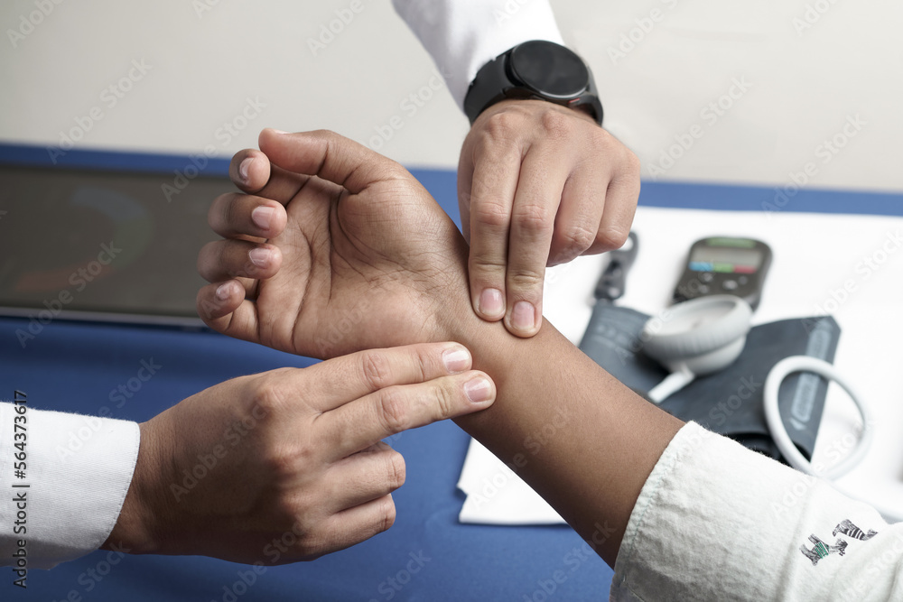 physician taking Allen's test on ulnar and radial artery in physician's office