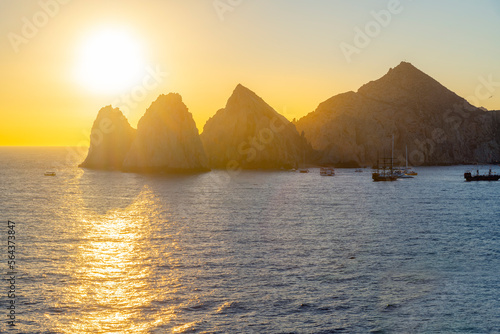 The morning sun appears over the El Arco coastal rocks at the Mexican port city of Cabo San Lucas, Mexico.  © Kirk Fisher